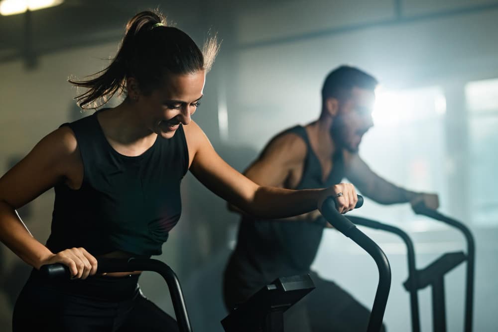 Mujer y hombre haciendo cardio en el gimnasio